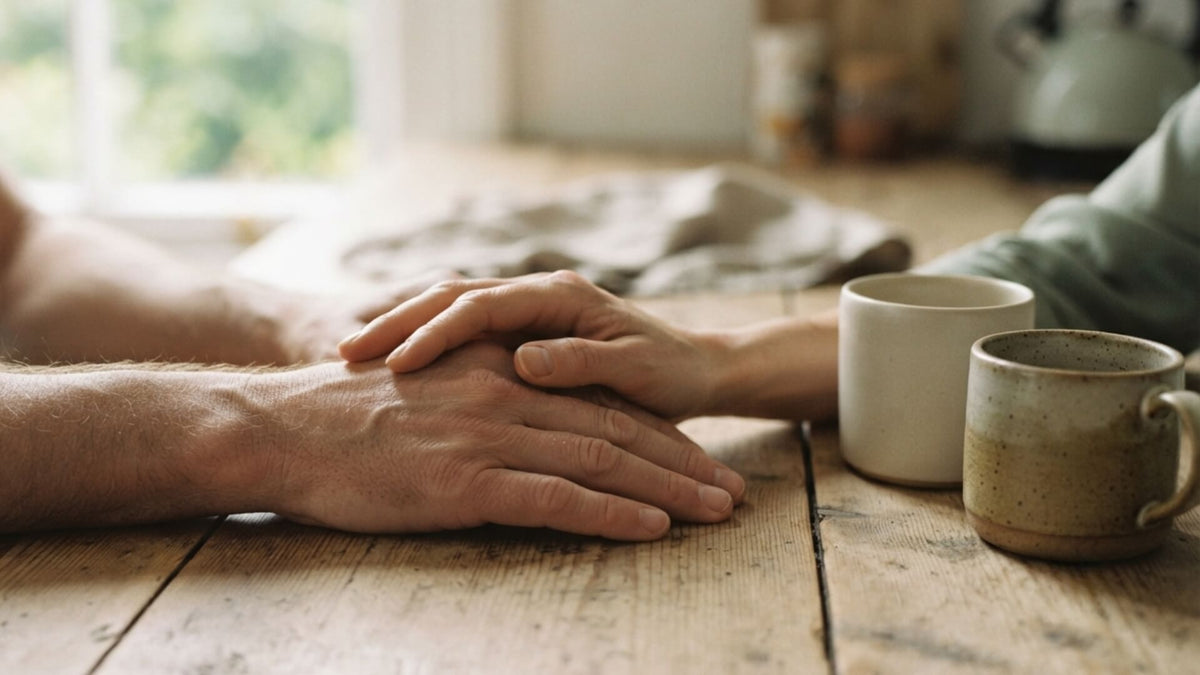 Couple attablé face à face dans la lumière du matin, deux tasses posées entre eux — endométriose et fertilité